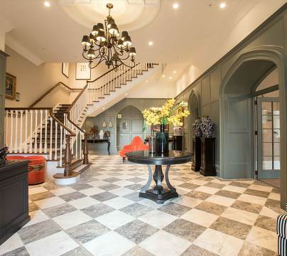 Reception area with chess tiles on the floor, chandelier and luxury decor