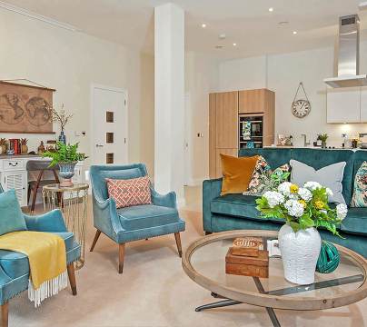 Living room with teal furniture and round glass coffee table