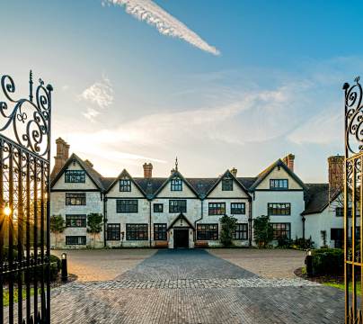 Wrought iron gates and Tudor mansion