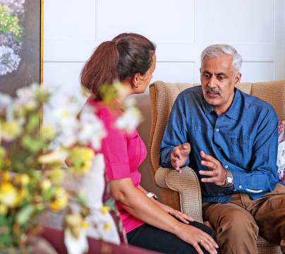 Seated man talking with carer