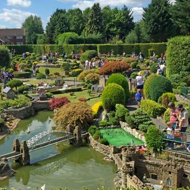 A model village with small trees and a river with bridge