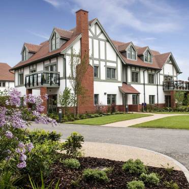 Apartment block with hip roof and faux-timbered design
