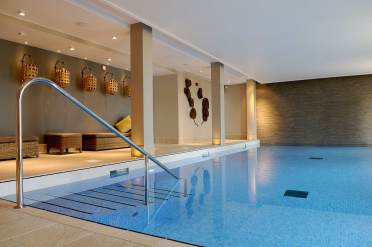 Swimming pool at Audley Chalfont Dene Warm colours and soft lighting around blue pool