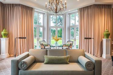 A bright lounge with wide windows and chandelier