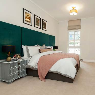 A bright bedroom with a blush pink blanket