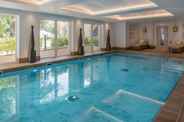 Indoor pool with loungers and large windows