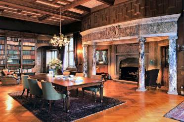 The stone fireplace with marble surround is the centrepiece of Flete House's library Giant stone fireplace with marble surround