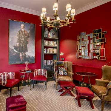 Burgundy interior of a luxury lounge with bookshelves and chandelier