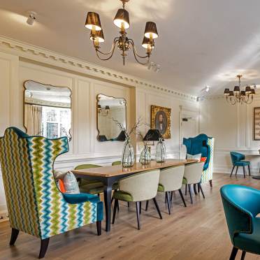 Private dining room with chandelier and high armchairs on the sides