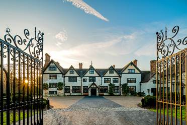 Wrought iron gates and Tudor mansion