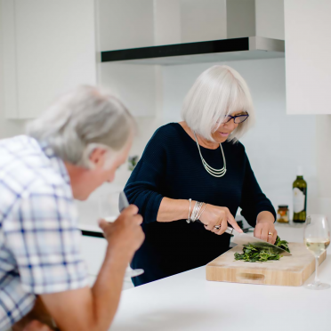 Senior couple preparing food with wine