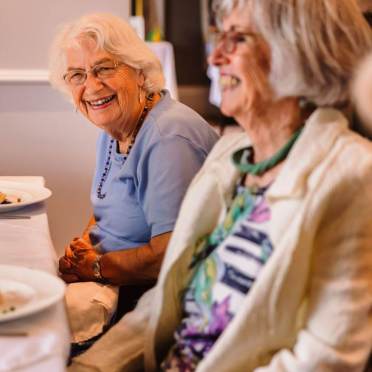 Smiling senior ladies at table