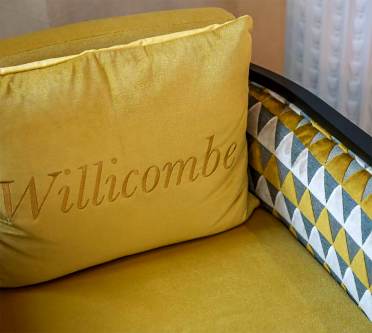 Yellow cushion with Willicombe branding