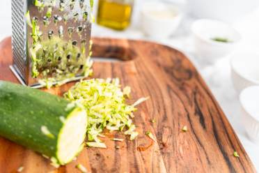 Half grated courgette near the grater 