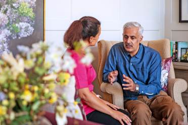 Seated man talking with carer