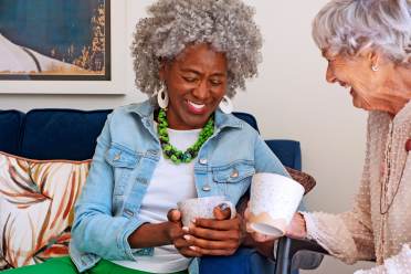 Two women laughing over coffee