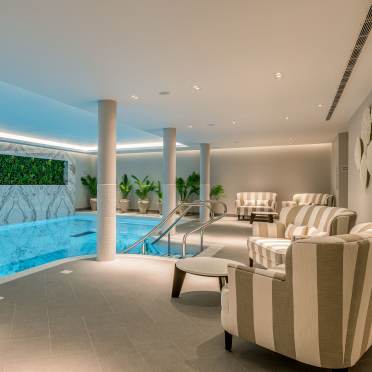 Indoor pool with pillars and soft lighting
