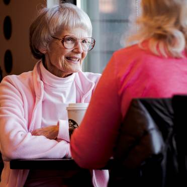 Smiling senior en face chating a lady