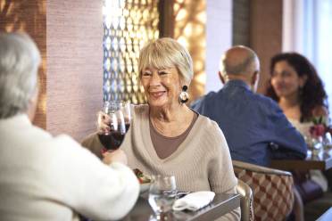 No3 at Nightingale Place Two older adults enjoying drinks and conversation at a restaurant, with another couple seated in the background.