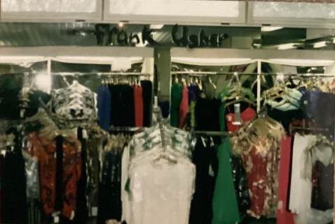Clothing store interior with racks of colorful garments.