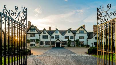 Wrought iron gates and Tudor mansion