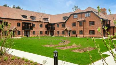 Red brick apartment block with lawn