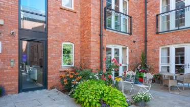 Red brick building with Juliet balconies on the first floor