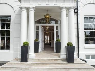 Covered entrance with columns and stone steps