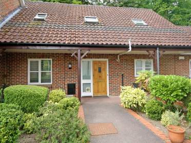 Cottage with shrubs around front path