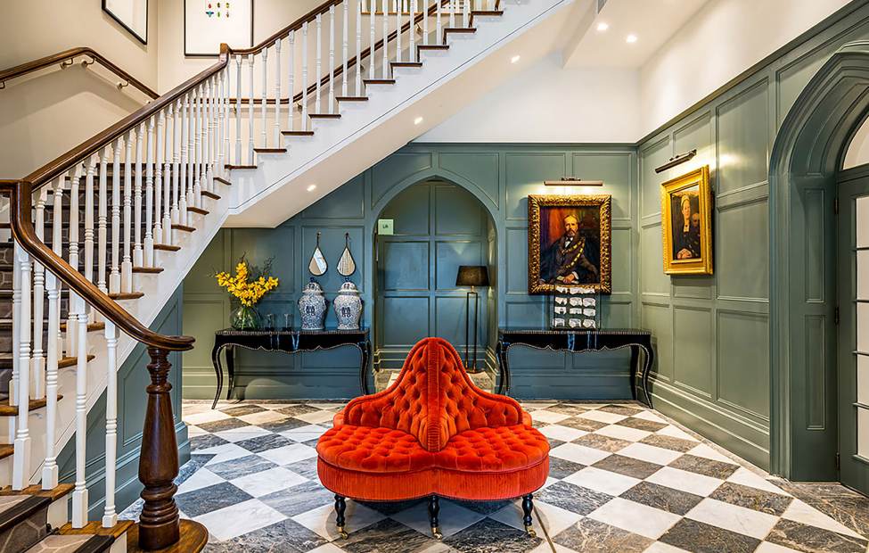 Reception area with chess tiled floor, coral seat and staircase