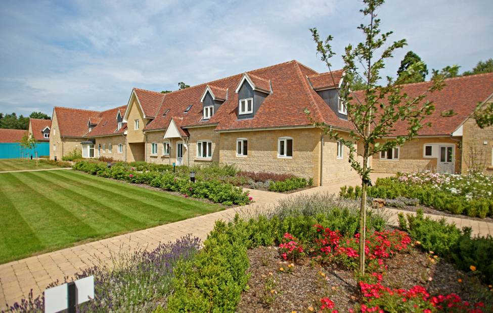 Cottages and gardens at Audley Mote House, Bearsted Stone cottages with lawns and flowers