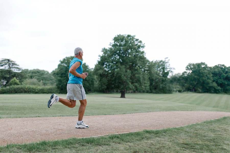 Side view on a running senior in park